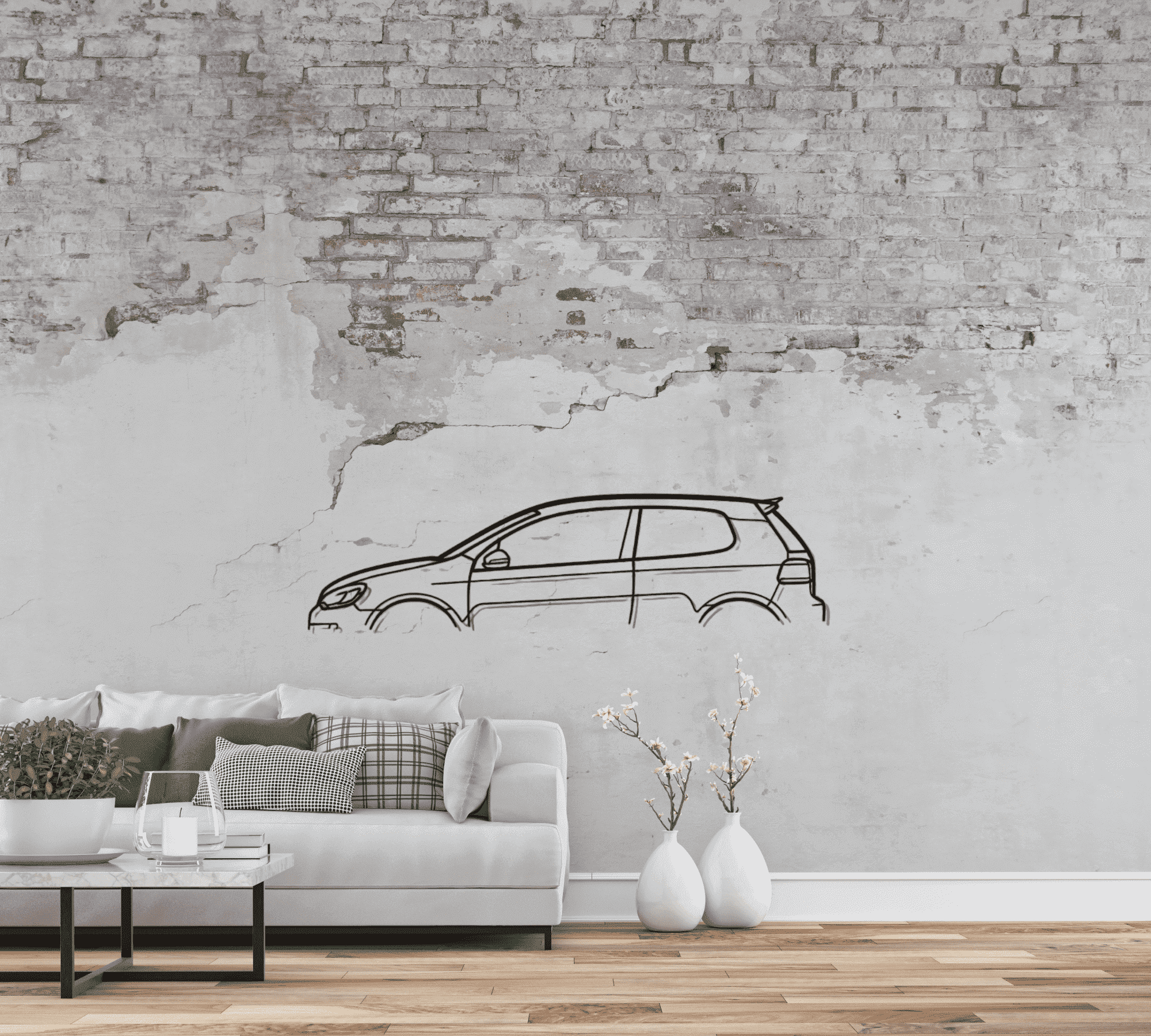 In dem Bild ist ein modernes Wohnzimmer mit hellgrauem Sofa, mehreren Zierkissen und Couchtisch zu sehen. Links steht ein weißer Blumentopf mit grüner Pflanze. Im Hintergrund befindet sich eine Wand mit abblätternder, teils freiliegender Backsteinstruktur. An der Wand ist eine schwarze, lineare Zeichnung eines Autos, vermutlich VW Golf 6 GTI, angebracht. Rechts neben dem Sofa stehen zwei weiße Vasen mit weißen Blüten. Der Boden besteht aus Holzparkett.